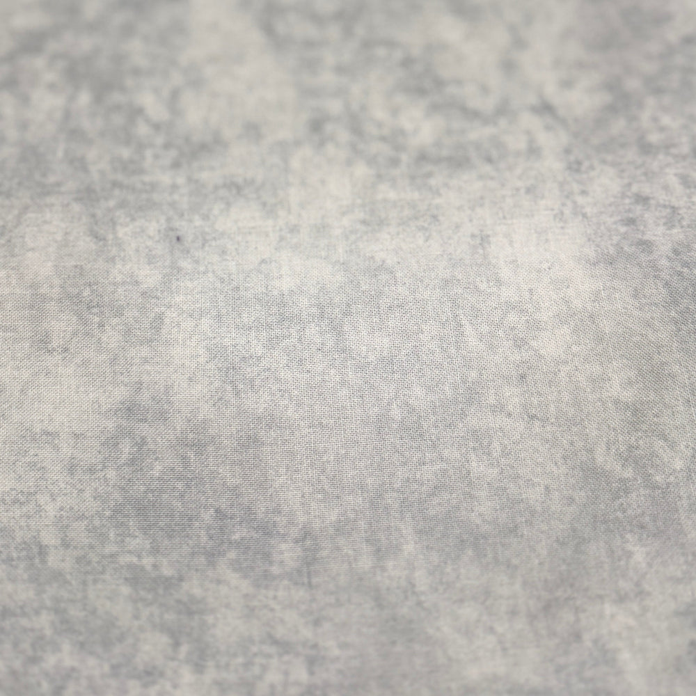 A close-up of a light gray to off-white textured surface with a mottled, stone-like or concrete-like pattern.