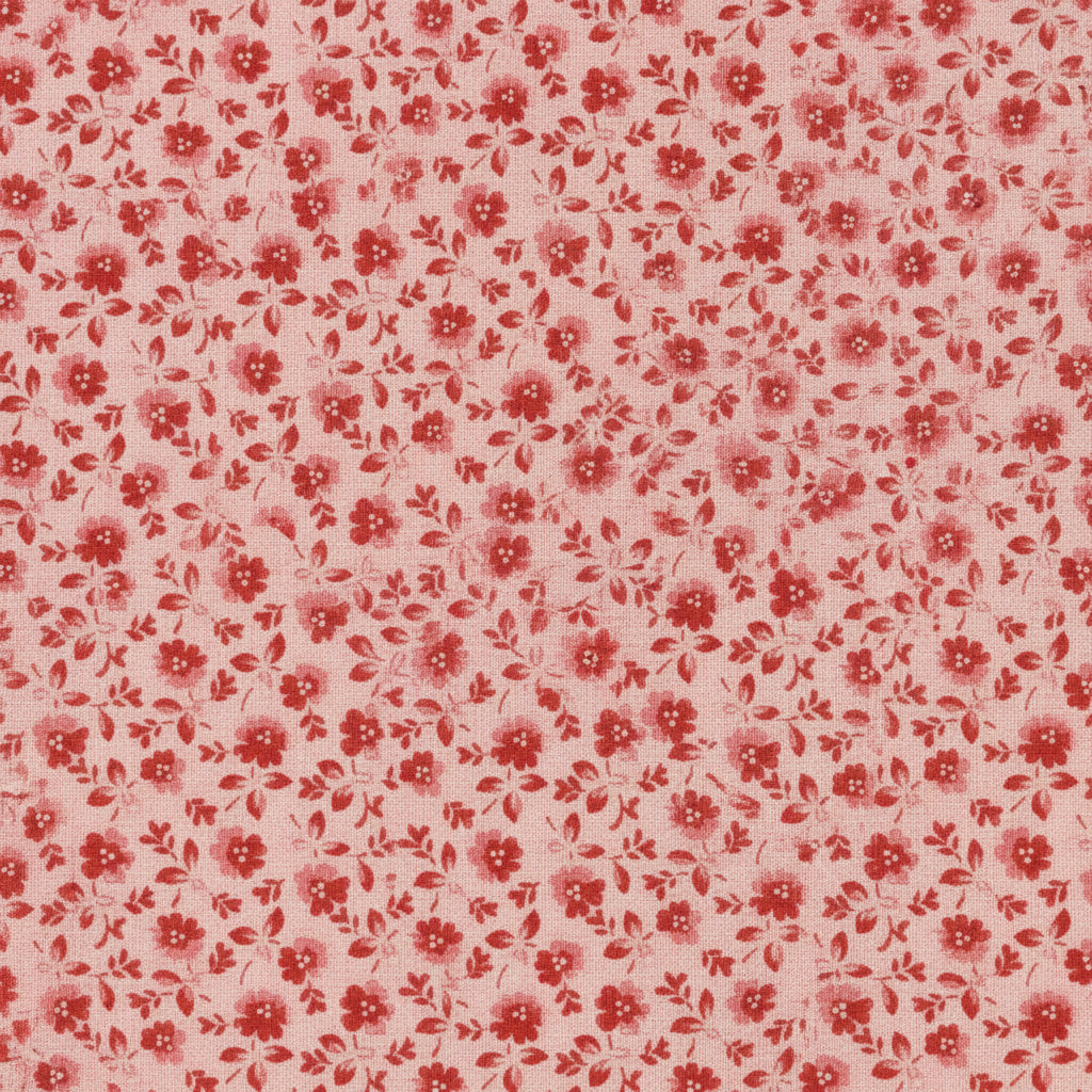 A close-up of a fabric pattern featuring small red flowers and leaves on a light pink background, with a white ruler along the bottom edge showing measurement markings.