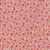 A close-up of a fabric pattern featuring small red flowers and leaves on a light pink background, with a white ruler along the bottom edge showing measurement markings.