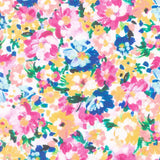 A close-up of a floral fabric pattern with pink, blue, yellow, and white flowers on a white background, with a ruler scale visible along the bottom edge.