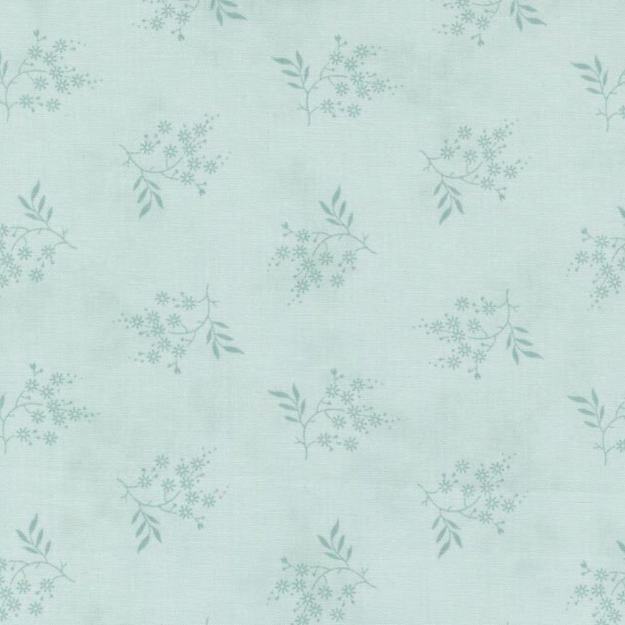 A close-up of a fabric or wallpaper pattern featuring a repeating design of delicate sage green floral branches on a light mint green background.