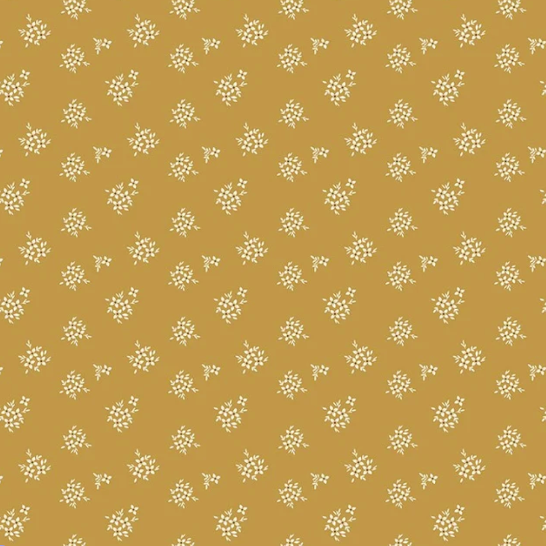 A repeating pattern of small white floral clusters on a warm mustard-yellow background.