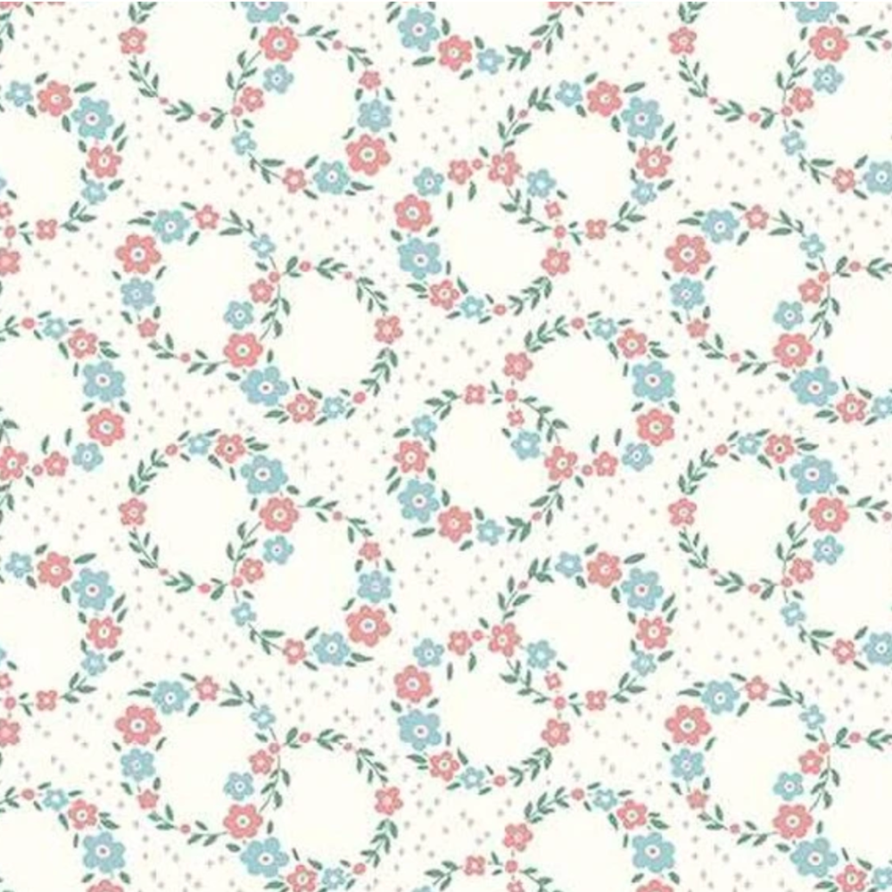 A repeating floral pattern on a warm off-white background, featuring small pink and light blue flowers with green leaves arranged in oval wreaths and dotted accents.