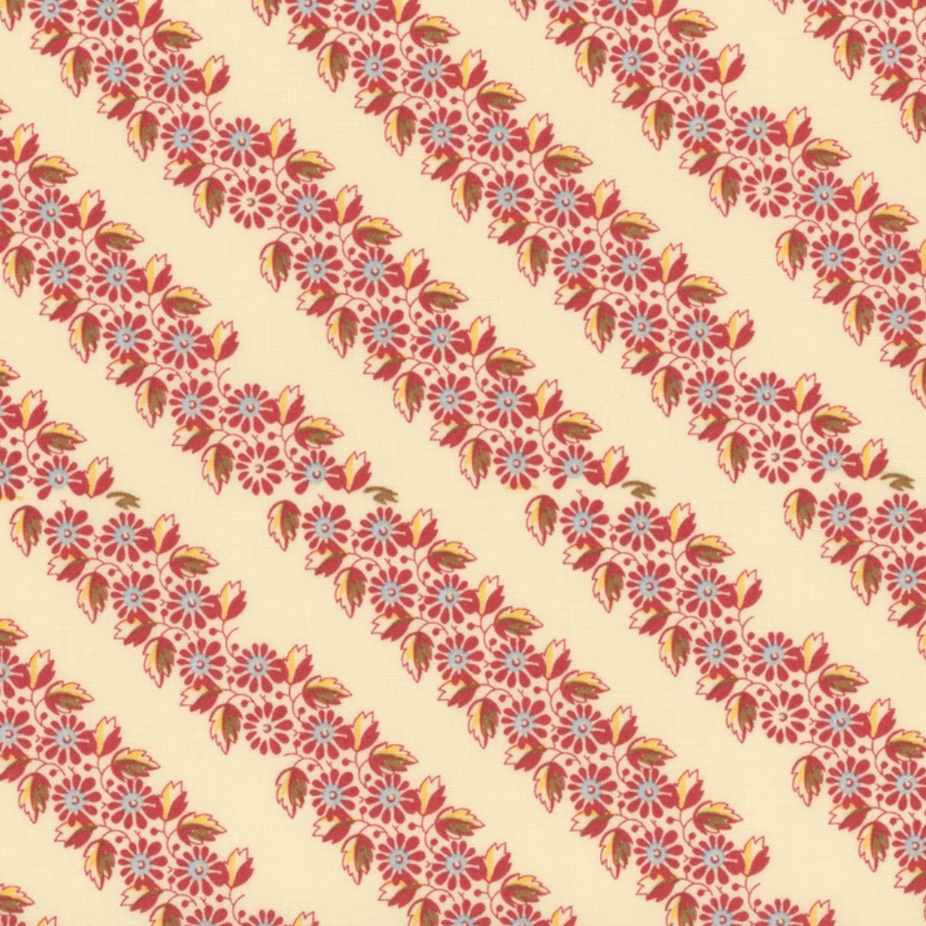 A repeating floral pattern arranged in diagonal stripes on a warm cream background. The motifs include red and pink blossoms, orange and yellow leaves, and small light blue star-like centers.