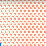 A repeating pattern of coral-pink four-petal flowers arranged in rows on a warm off-white background.