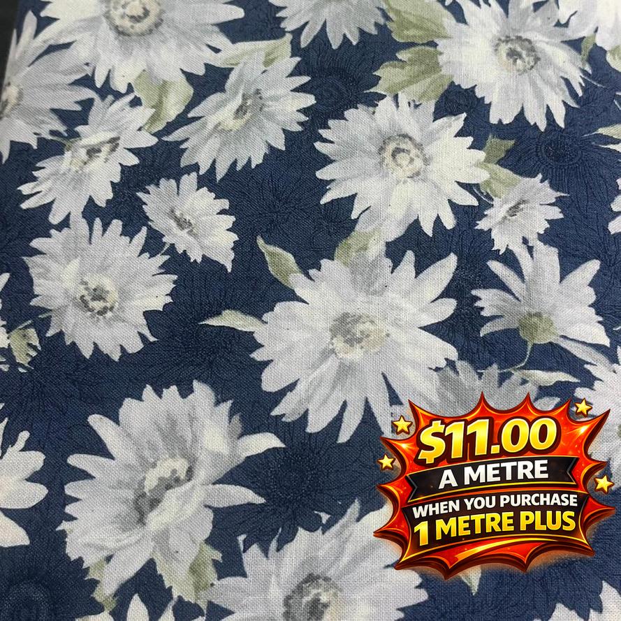 Seeded cotton shirting fabric with white daisy floral print on a dark blue background.