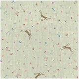 A close-up of a fabric or wallpaper pattern featuring a light sage green linen-like background with a scattered print of brown deer, colorful wildflowers, and small botanical motifs.