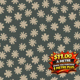Dark green cotton fabric with scattered light beige starburst patterns, priced at $11.00 a metre.