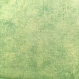 A close-up of a textured fabric or wallpaper material in a mottled sage green and light yellow-green color.
