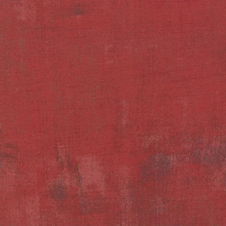 Red fabric swatch with a textured pattern and a ruler at the bottom for scale.