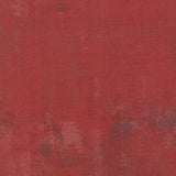 Red fabric swatch with a textured pattern and a ruler at the bottom for scale.