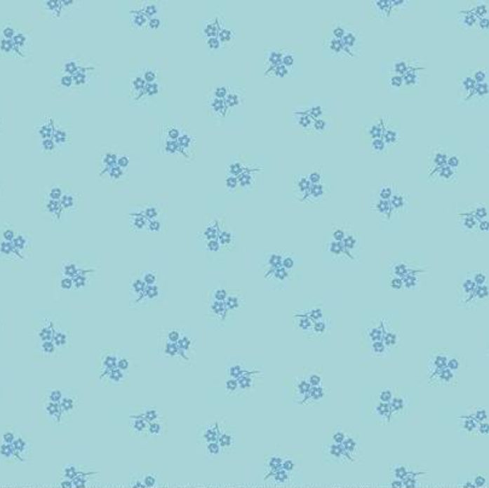 Light blue fabric with a repeating pattern of small blue floral sprigs, shown with a ruler along the bottom edge for scale.