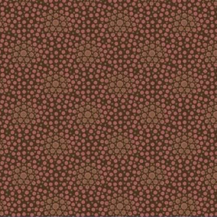 A close-up of a fabric pattern with a dense repeating design of small pink dots over a warm brown and tan background, with a ruler along the bottom edge showing measurements.